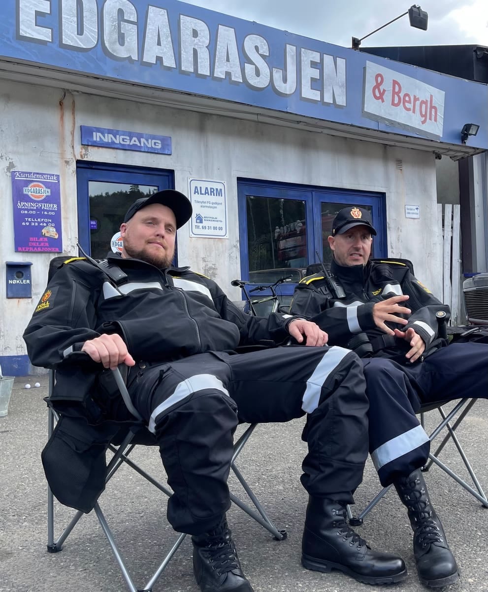 To kledd i uniform slapper av foran Edgarasjen-skiltet